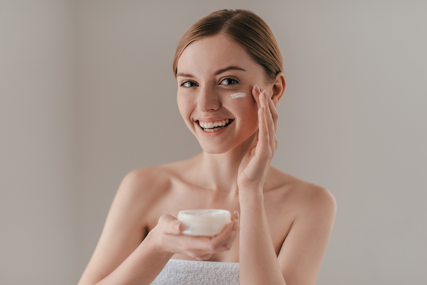 taking good care her skin attractive young woman looking camera smiling while standing against background